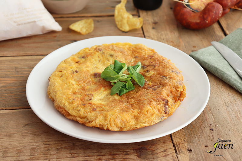 Tortilla de patatas fritas con pan y chorizo.